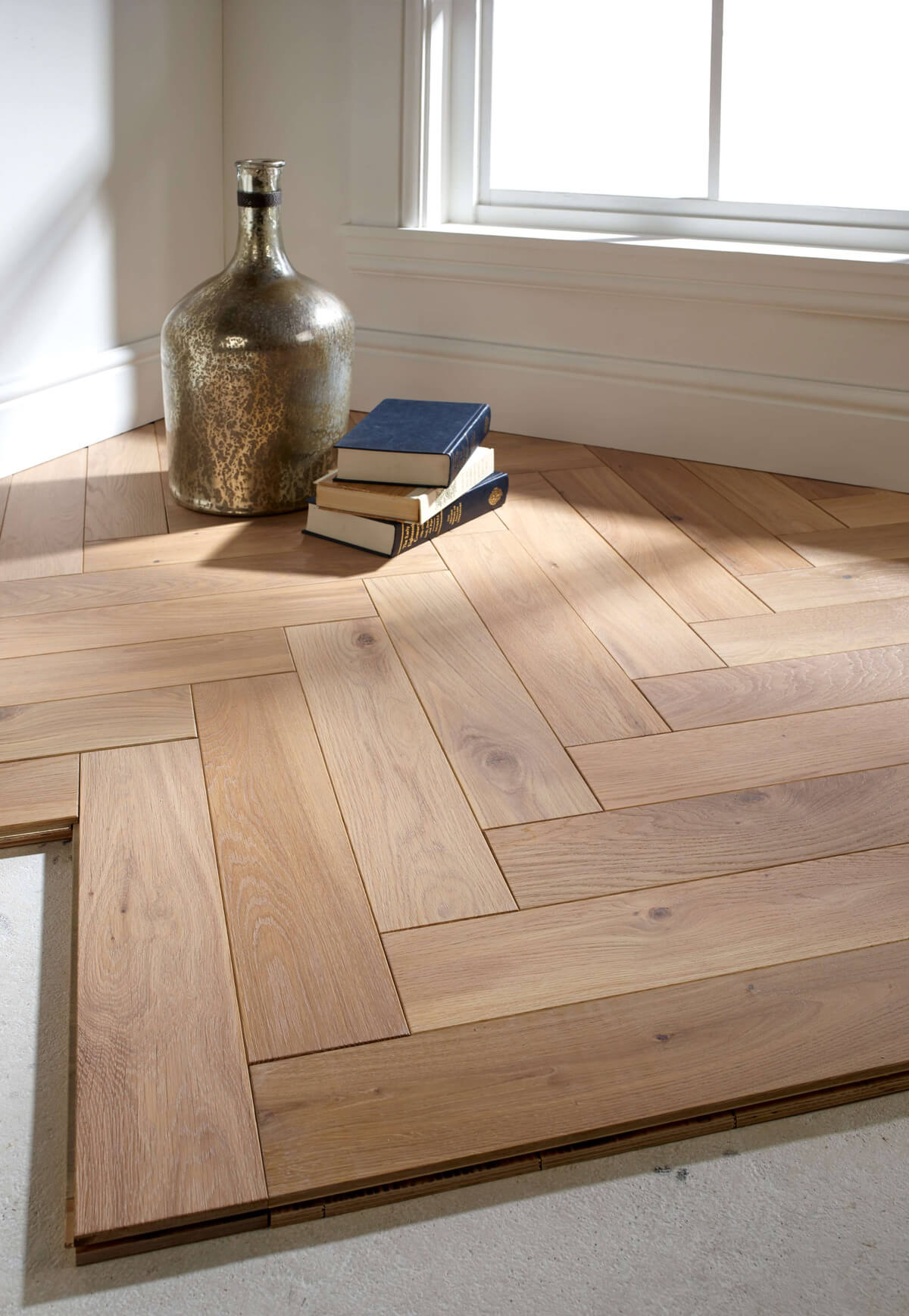 Parquet wooden flooring with a stack of books and vase
