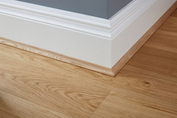 A close-up of wooden flooring and a skirting board.